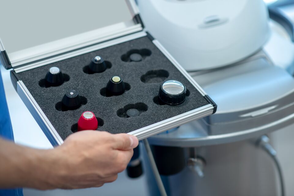 Close-up of male hands holding box with ultrasound machine changable heads