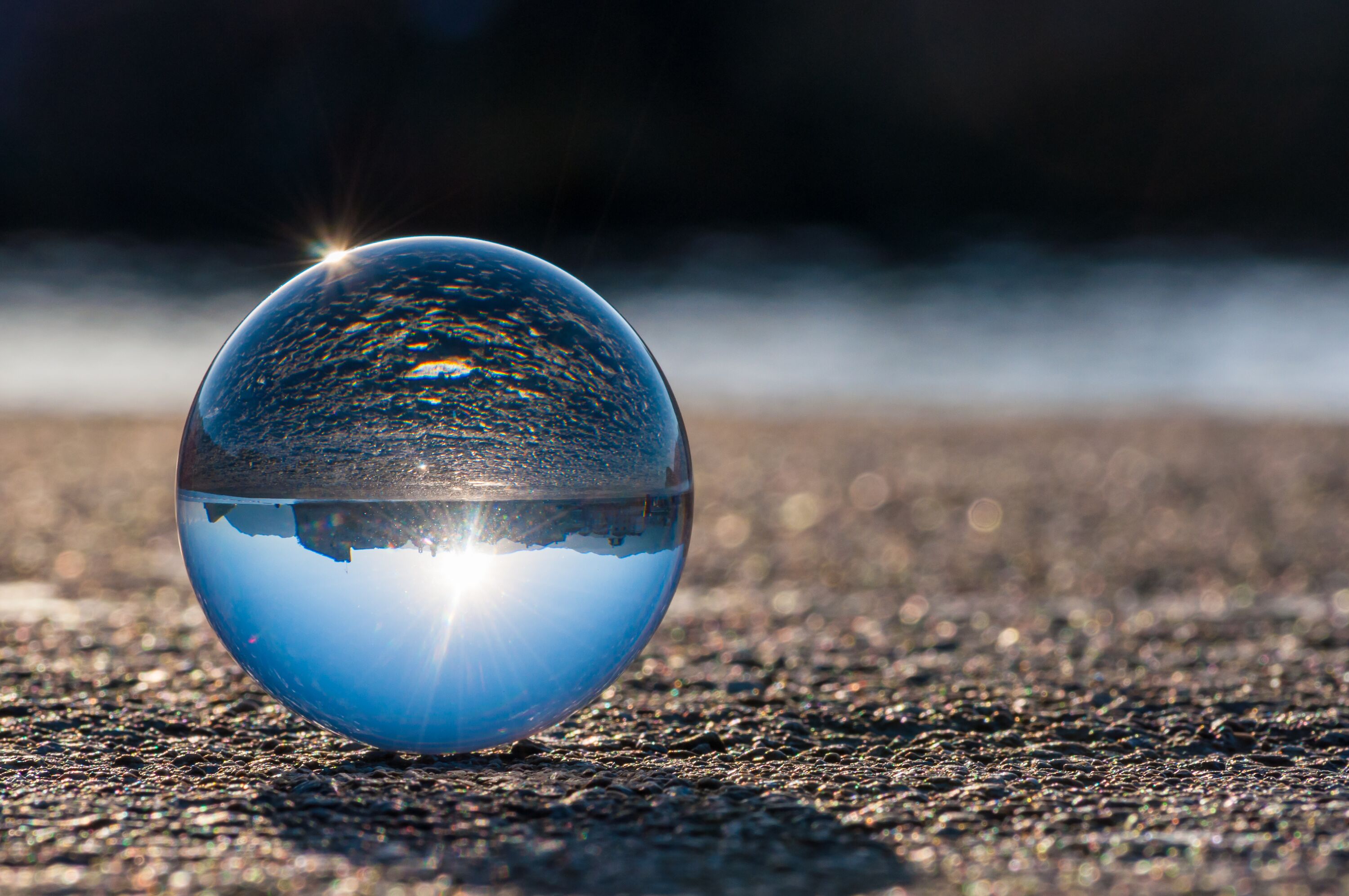 Glass transparent ball on dark background and grainy surface