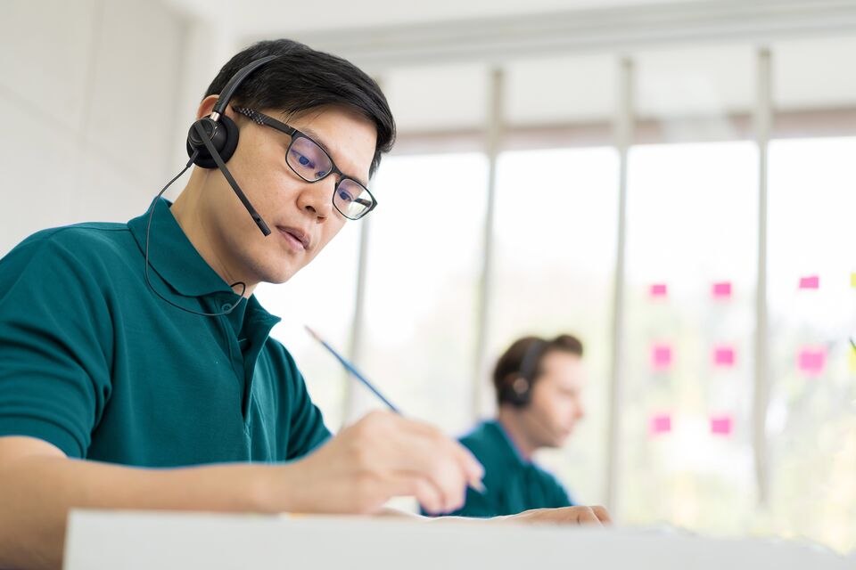 Team of customer service call center with headset working with computer. Group of technical support operator customer service in the office