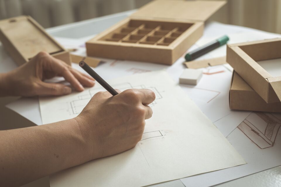 The designer draws sketches for cardboard packaging