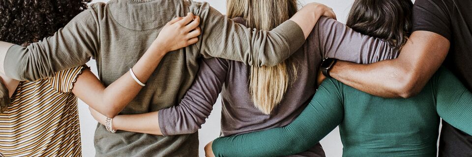 Rearview of diverse people hugging each other
