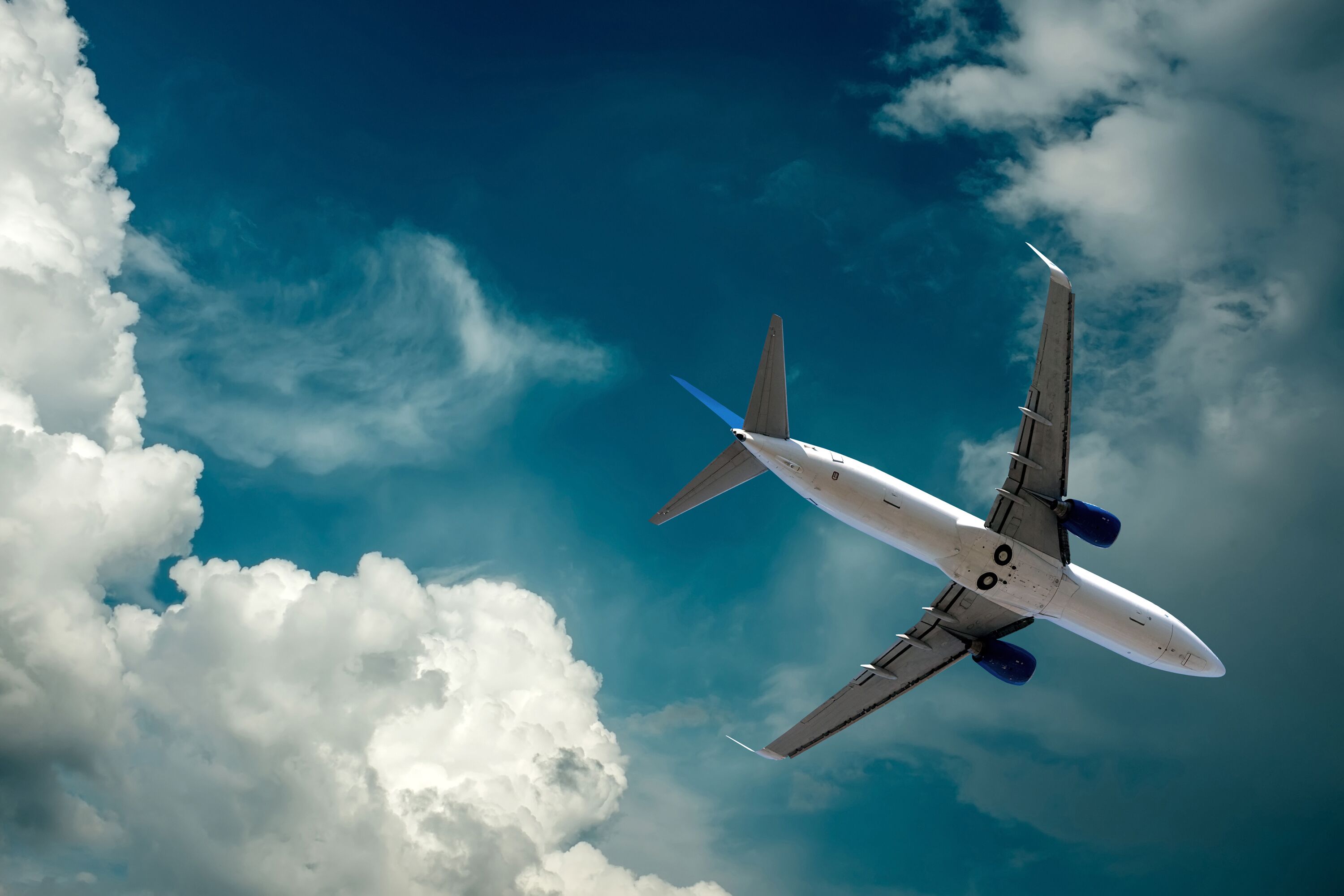 Airplane at flying under sky with clouds