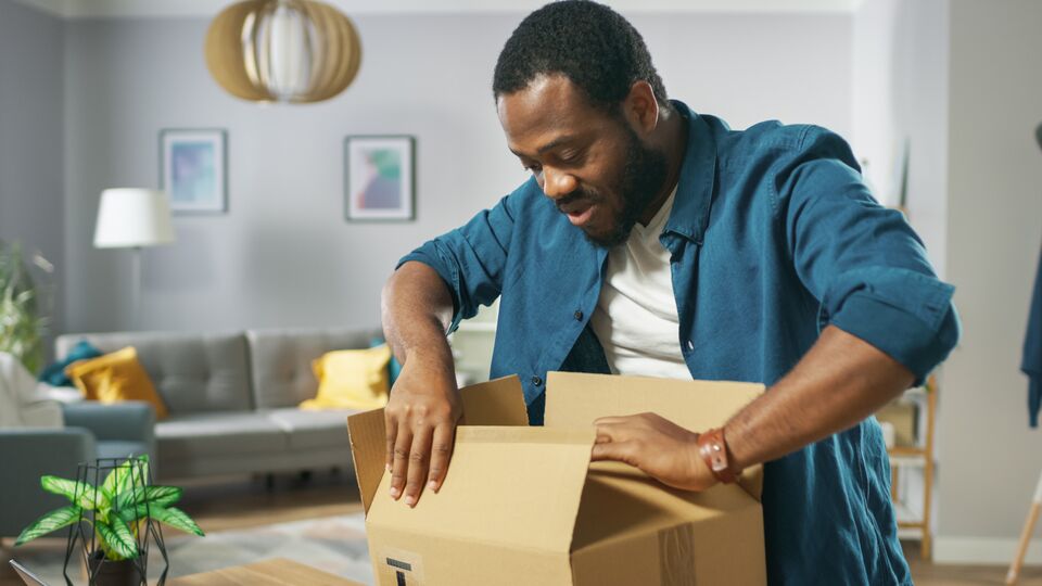 Handsome Excited Man Opens Cardboard Box Postal Package and Is Very Happy with Content. Man Package Unboxing