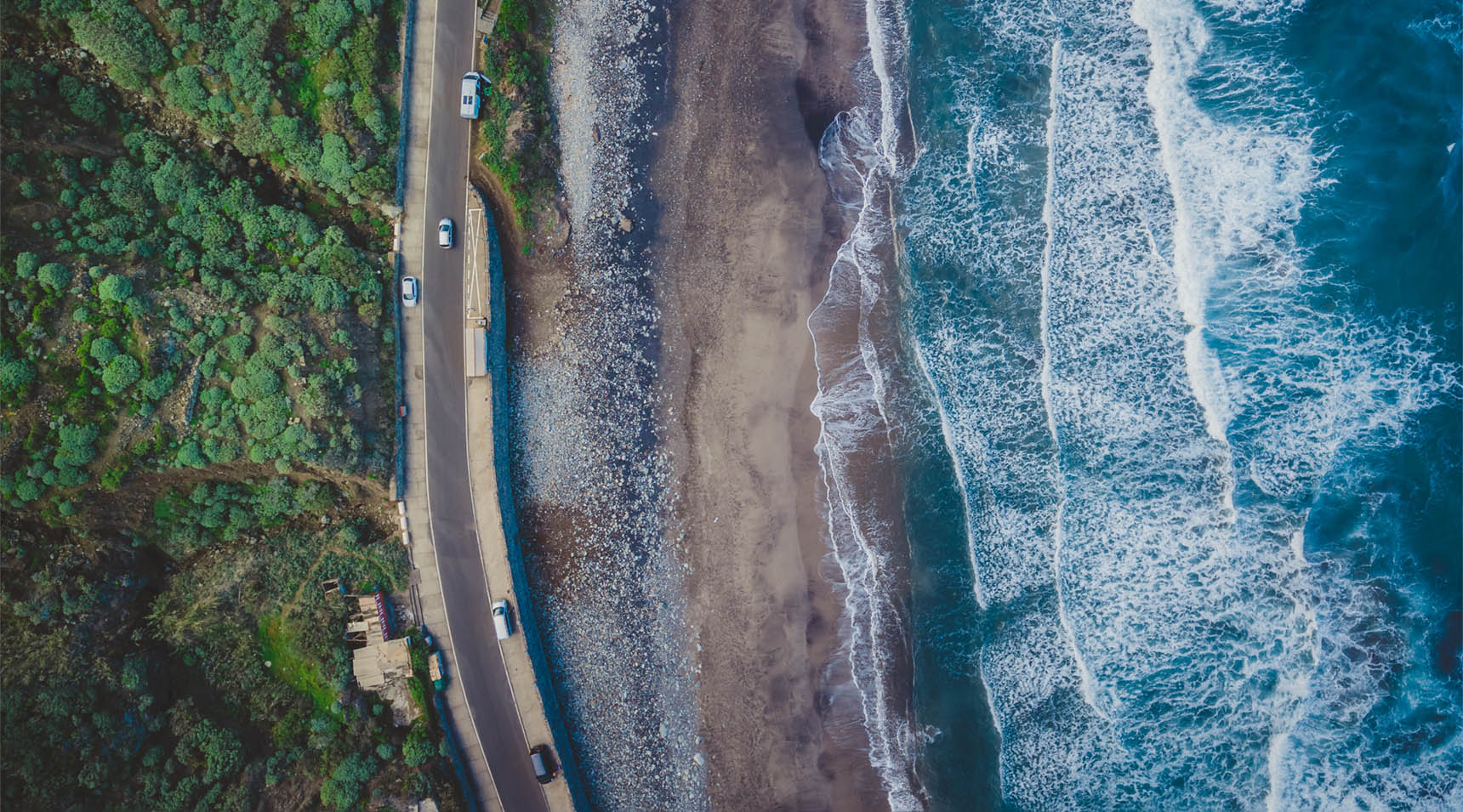 Volcanic sunset beach in Tenerife, Benijo. Paradise beach in Canary Island. Flight above ocean waves, washing up on a black volcanic sand beach. Aerial shot of tide, sea, wide dramatic landscape view