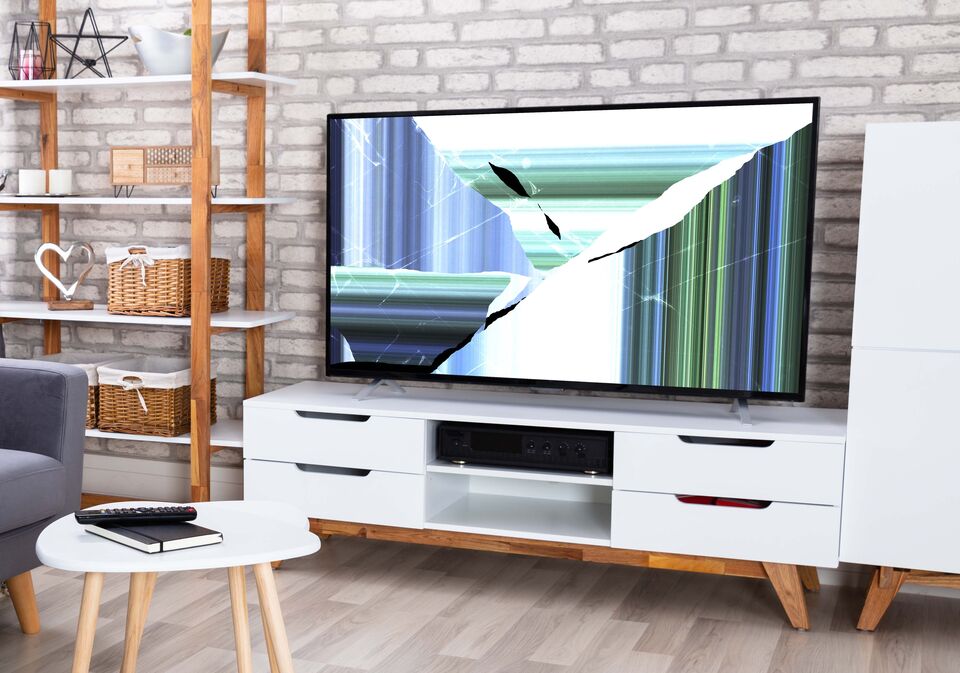 Man Looking At Broken Television Set